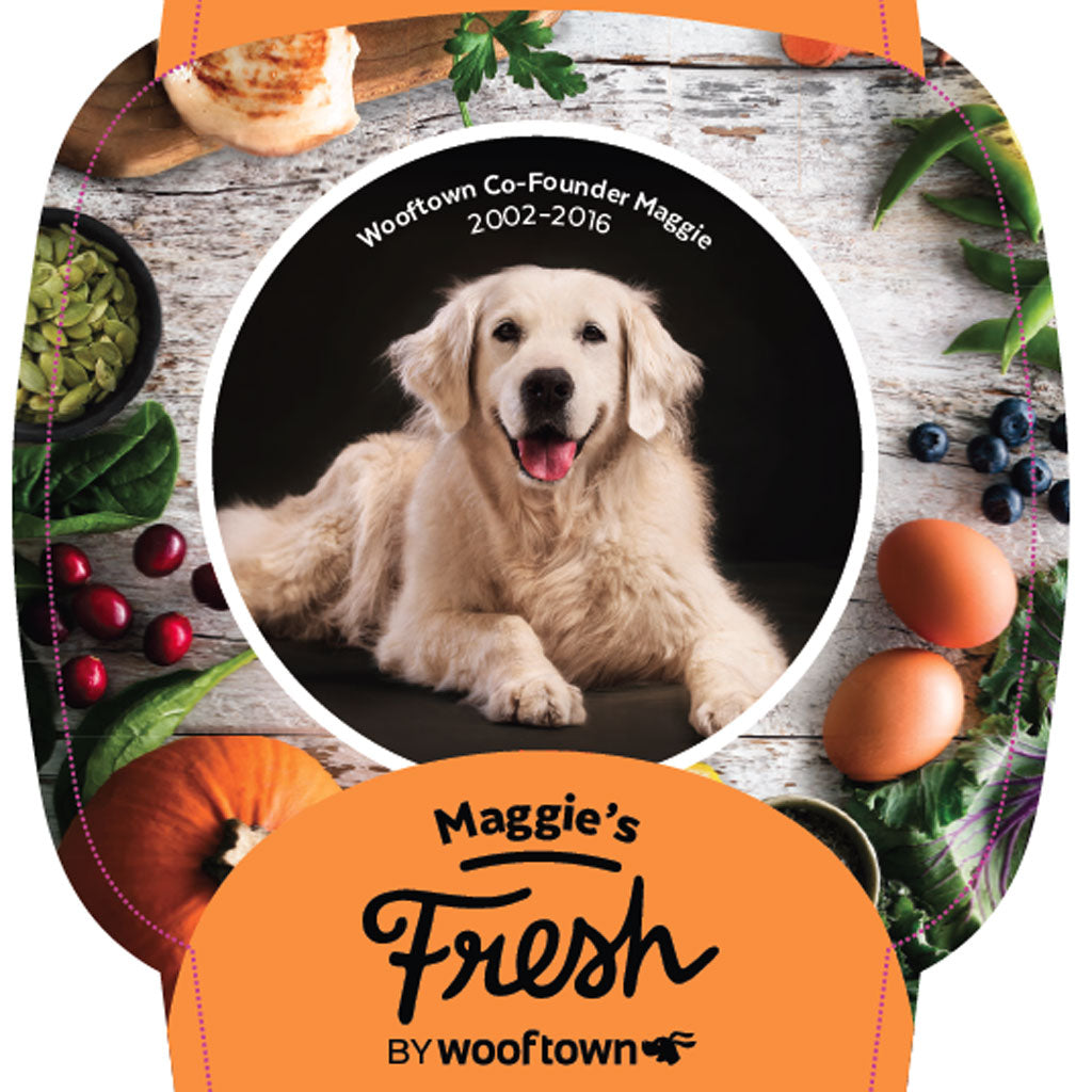 Maggie on a label surrounded by fresh ingredients, celebrating Maggie, co-founder of Wooftown, from 2002 to 2016.